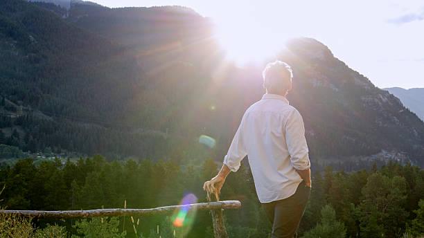 istock Mature leans on fence and uses mobile phone 2237619098