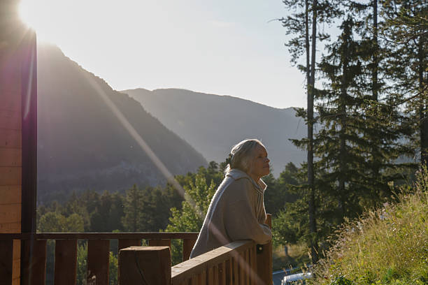 istock Mature woman enjoys sunrise from deck 2237619163