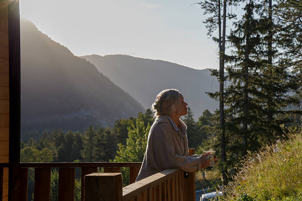 istock Mature woman enjoys hot beverage on deck at sunrise 2237619165