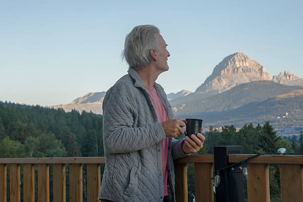istock Mature man enjoys hot beverage on chalet deck 2237619177
