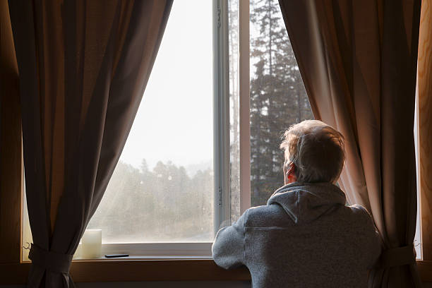 istock Mature man watches sunrise through bedroom window 2237619202