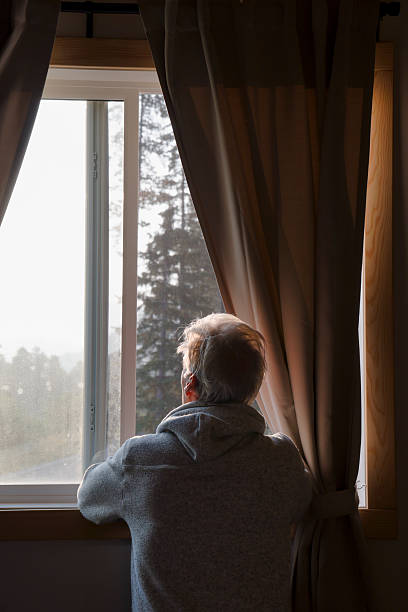 istock Mature man watches sunrise through bedroom window 2237619205
