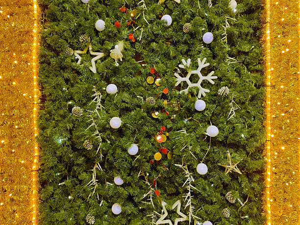 Decorated Christmas tree with golden lights and various festive ornaments