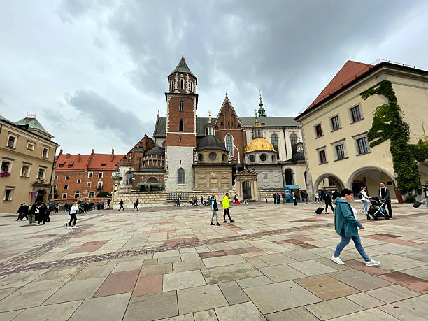 Kraków, Poland - September 24, 2023: People exploring the historic Wawel Cathedral grounds on a cloudy day in Krakow