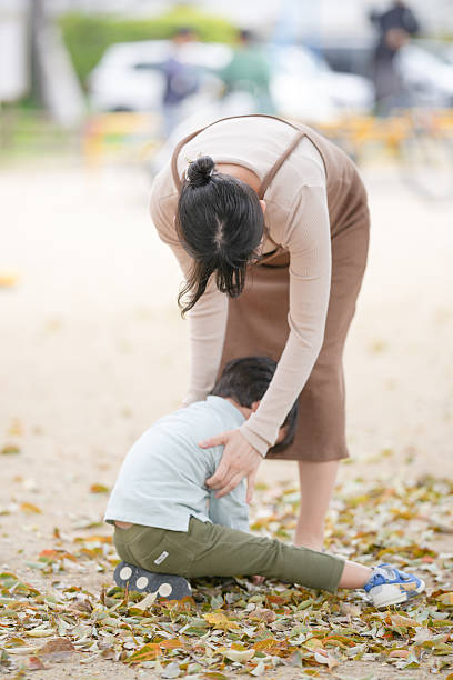 istock A woman is helping a child who is lying on the ground 2237637568