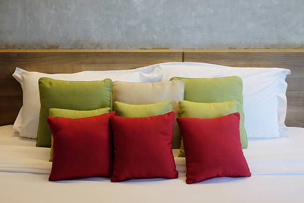 Green and red backrest pillow decorated on white bed