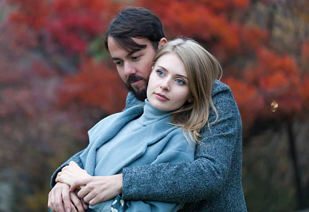 Beautiful couple spending time in park on autumn day
