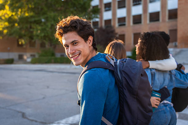 istock Young student smiling while walking with friends on university campus 2237658751