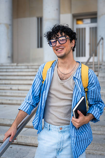 istock Young man student smiling on university campus stairs 2237658778