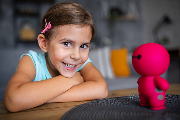 istock Child communicating with artificial intelligence toy robot in living room 2237660301