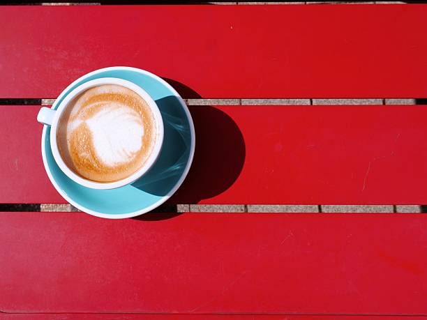Cappuccino or latte with foam art on red table