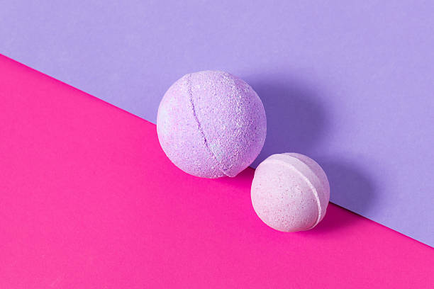 istock Colorful bath bombs on vibrant pink and purple background create a playful scene 2237663790