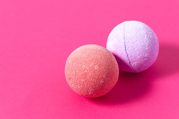istock Colorful bath bombs resting on bright pink background 2237663996