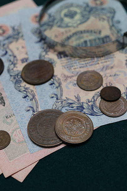 istock A collection of old coins and banknotes arranged on a dark surface, featuring various denominations and designs 2237666556