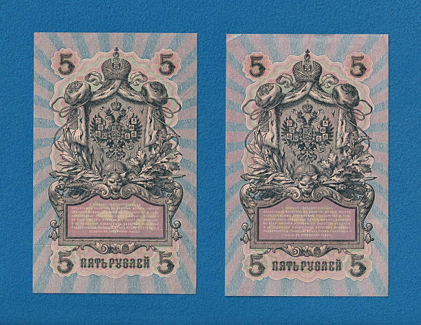 istock Two vintage banknotes of five rubles, featuring intricate designs and a central emblem with crowns and decorative elements, set against a blue background 2237666585