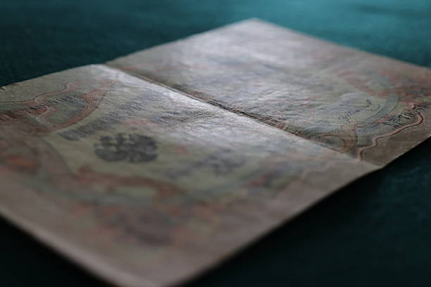 istock An open vintage book or document with intricate designs and faded text, resting on a textured green surface 2237667148