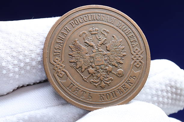 istock A vintage russian coin held by a gloved hand, featuring intricate designs and inscriptions, showcasing historical significance 2237667583