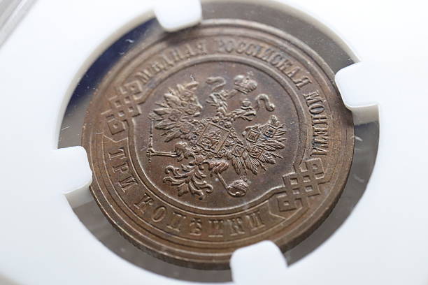istock An antique Russian coin featuring the double-headed eagle emblem, with inscriptions in Cyrillic, housed in a protective case 2237667705
