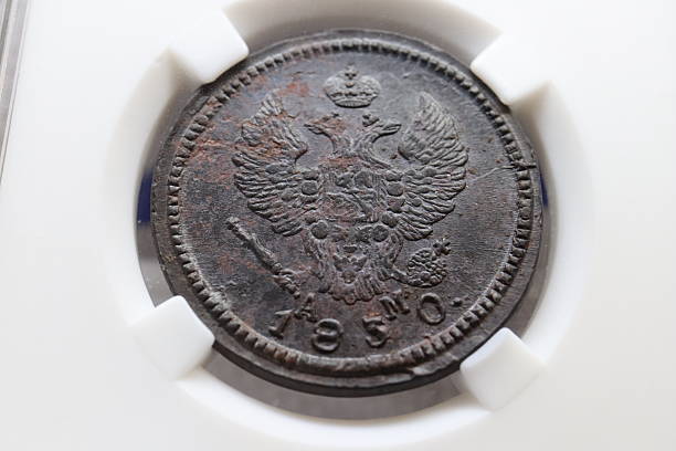 istock An antique coin featuring a double-headed eagle emblem, dated 1850, with intricate details and a worn surface, displayed in a protective holder 2237667782
