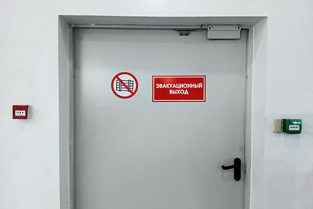 istock A closed door on a white wall with a red sign. The sign in Russian reads: emergency exit. 2237669668