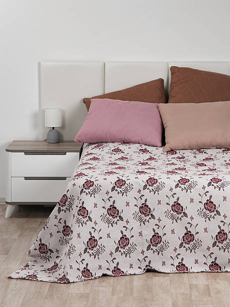 istock A bed with colorful pillows and a jacquard bedspread with a floral pattern, a rug for an armchair 2237675209