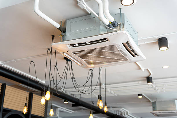 istock Ceiling Cassette Air Conditioner Unit in a Commercial Space, HVAC System and Exposed Ventilation Ducts on an Industrial Ceiling, Air Conditioning and Lighting Fixtures in an Office or Cafe 2237676638