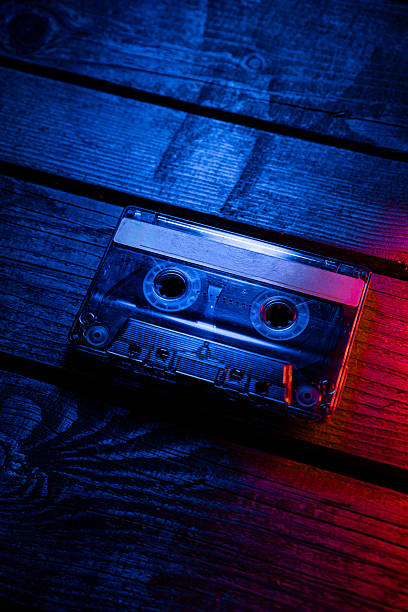 istock A cassette tape on dark wooden planks with dramatic blue and red neon lighting. 2237676749