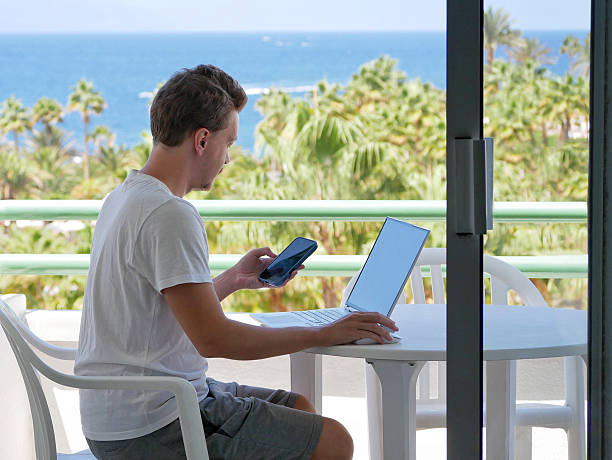 istock Remote Work with Laptop and Smartphone - Man on Tropical Balcony 2237678766