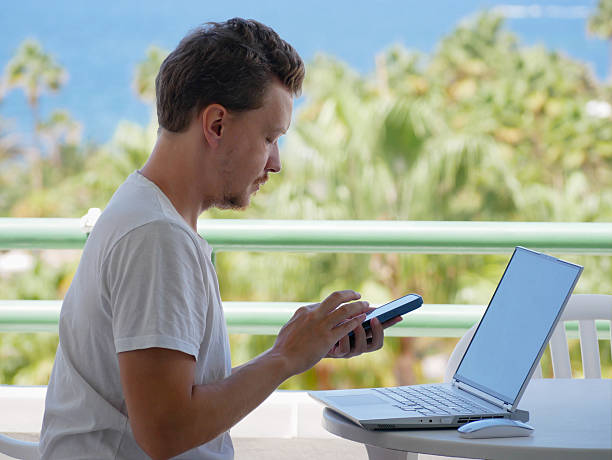 istock Remote Work with Laptop and Smartphone - Man on Tropical Balcony 2237678791
