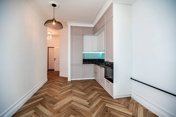 A kitchen with a white counter and a black oven. The kitchen is empty and has a clean, modern look. New renovation in Loft Style