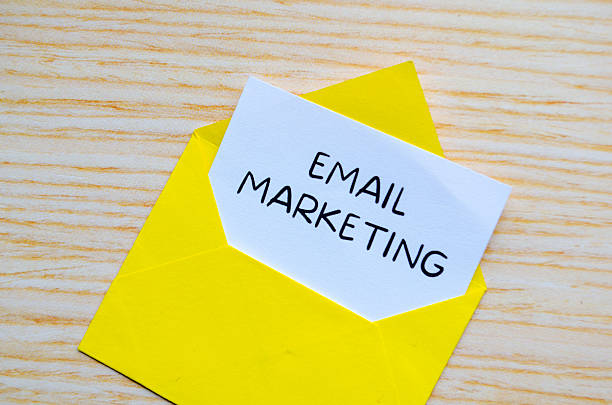 istock Email marketing text written on yellow notepad with envelope illustration clipped on wooden desk. 2237680762