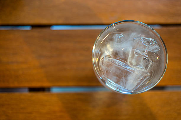 Ice cool water in glass on wood table. Top view