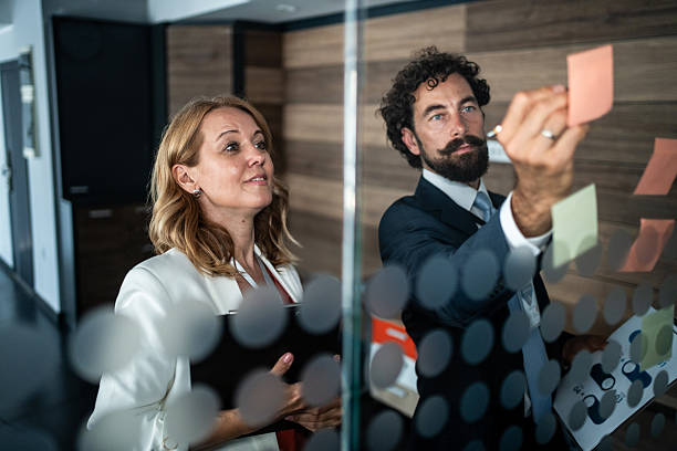 istock Business colleagues brainstorming ideas on glass board 2237687860