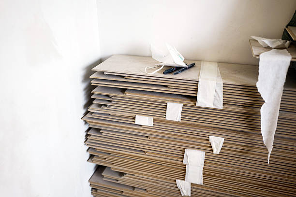 istock Stack of flat cardboard boards next to a wall in a workspace area 2237689039