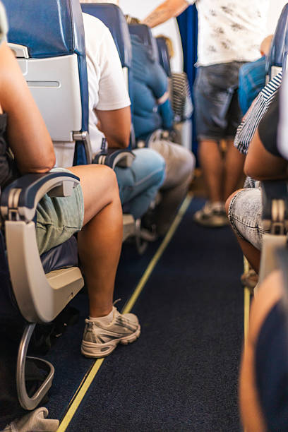 istock Inside the airplane cabin, passengers are seated comfortably while airline crew members prepare for takeoff. Visibility shows the aisle and seated travelers on a clear day 2237689319