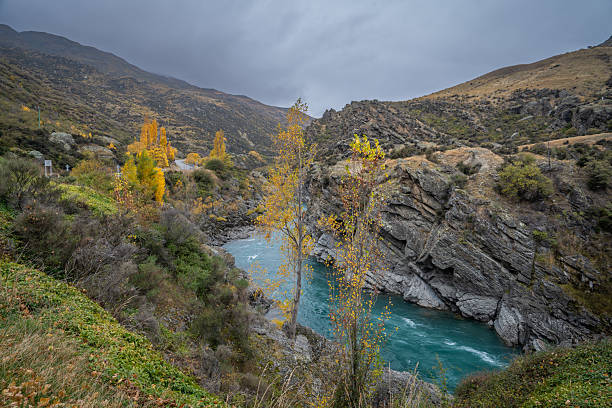 stunning view of turquoise kawarau river and yellow colorful leaves tree on the hill along the river is beautiful landscape of South Island New Zealand