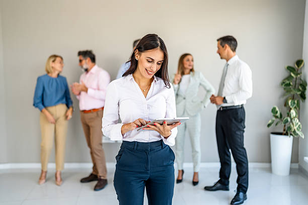 istock Businesswoman using digital tablet while colleagues talking in office 2237691542