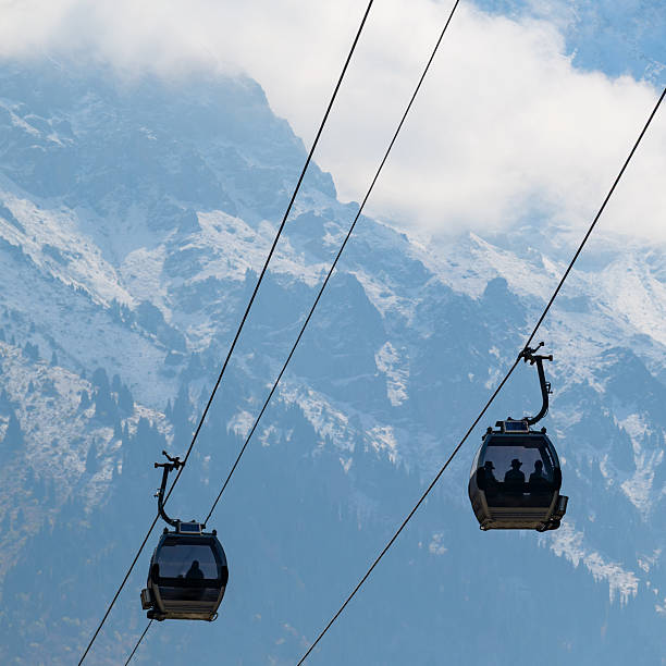 A cable car against the backdrop of a mountain range on a cloudy autumn day