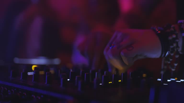 People dancing in front of of a DJ set up in nigth club