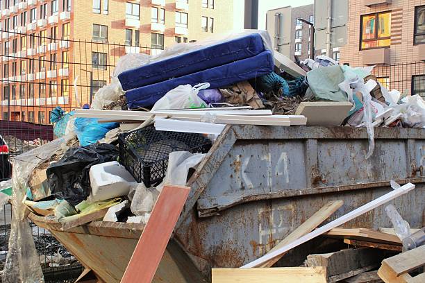 istock Overfilled dumpster in urban area. Construction debris overflowing a large container. Waste garbage bin with construction materials. Dumpster full of mixed construction and demolition waste 2237693071