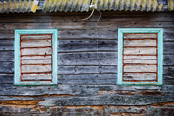 istock Boarded up windows decaying on abandoned house wall 2237693410