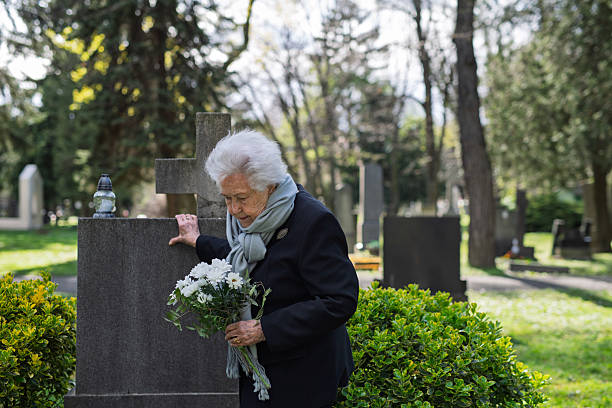 istock Old lady remembering a loved one at a grave. 2237699423
