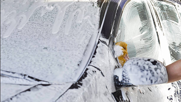 istock Car wash worker cleaning vehicle with sponge and soap 2237701541