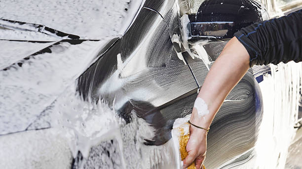 istock Car wash worker cleaning vehicle with sponge and foam 2237701940
