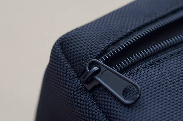 istock A sharp, close-up shot of a black zipper on a textured, grid-patterned fabric, emphasizing concepts of security, closure, and modern product design. 2237702001
