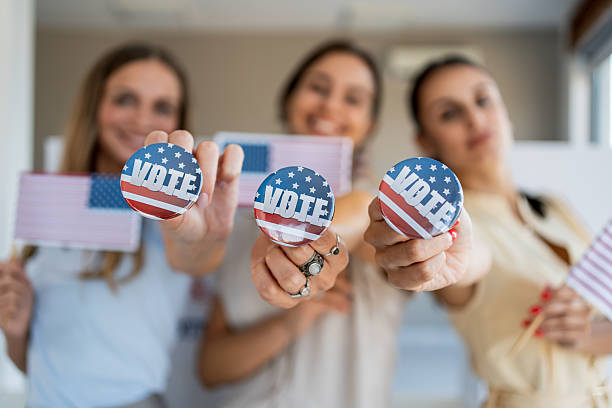 istock Three women showing vote buttons and American flags 2237710873