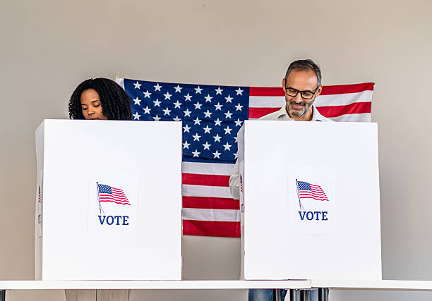 istock People voting in polling booth with American flag 2237711147