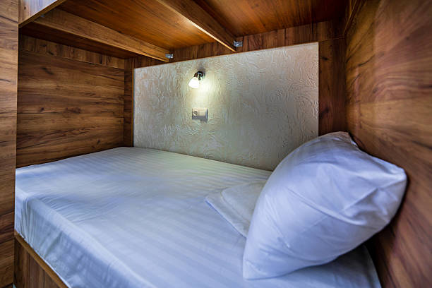 istock A room in a hostel. A wooden bunk bed with a white sheet and a white pillow 2237712626