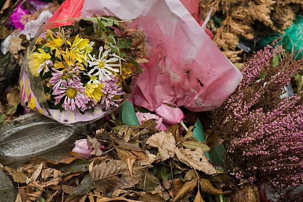 istock Discarded flowers with dry leaves and plastic waste in cemetery container 2237712662