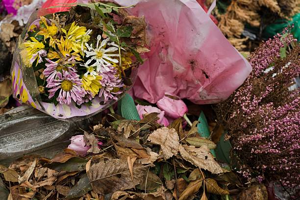 istock Discarded flowers with dry leaves and plastic waste in cemetery container 2237712674